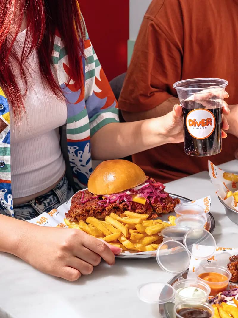 Masada burger ve içeceklerle sohbet eden arkadaş grubu.